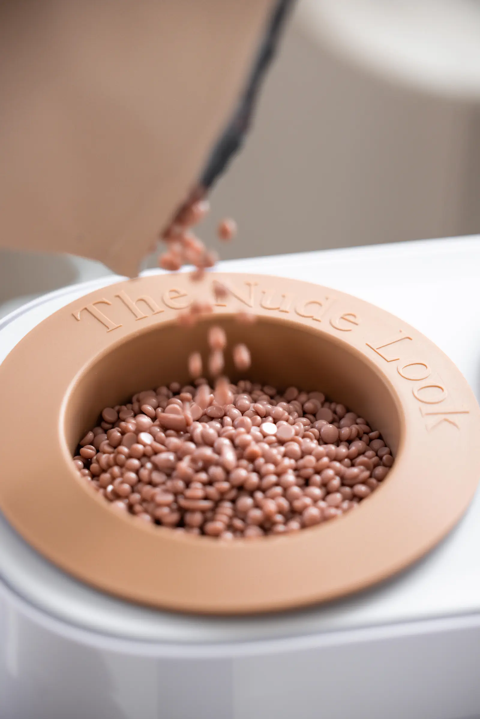 Depilatory wax beads styled during an intimate waxing service